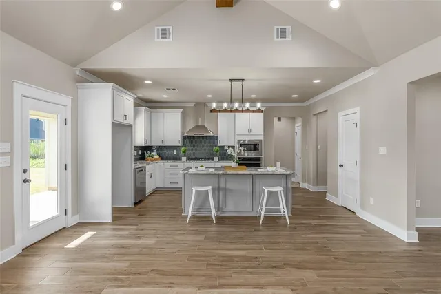 a large white kitchen with lots of counter space and stainless steel appliances
