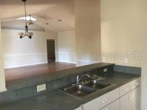 a kitchen with a sink and chandelier
