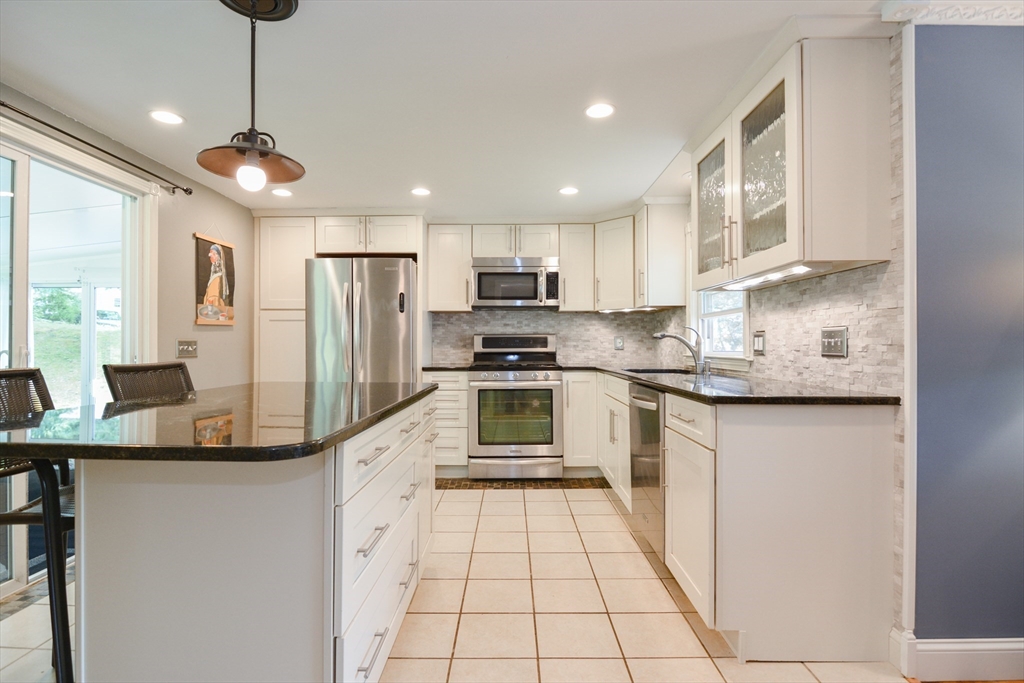 48 Smiths Lane Kingston, MA 02364 - Photo 5 of 38 a kitchen with stainless steel appliances granite countertop a sink a stove a refrigerator cabinets and chairs
