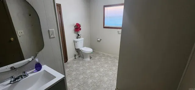 a view of a white house with a large space in front of it