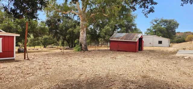 a backyard of a house with fire pit and trees
