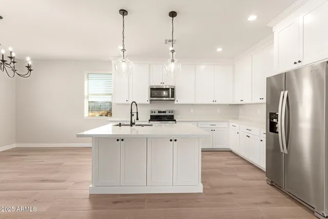 a kitchen with a sink a stove and wooden floor