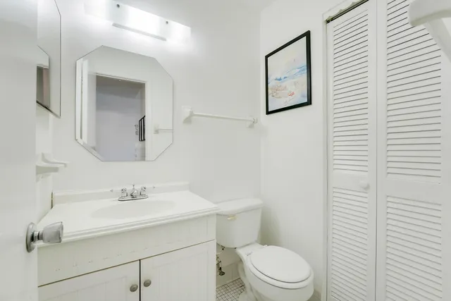 a bathroom with a sink mirror and toilet