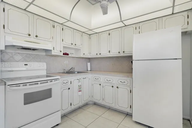 a kitchen with white cabinets and white appliances