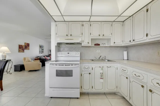 a kitchen with white cabinets and white appliances