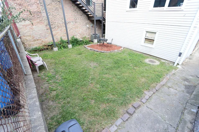 a view of a backyard with table and chairs and wooden fence