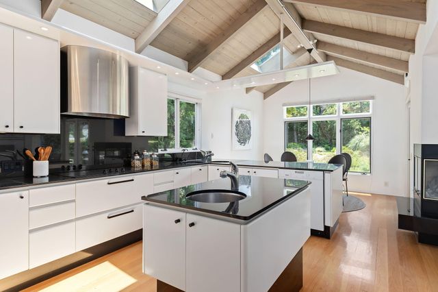 a kitchen with granite countertop a sink window and cabinets