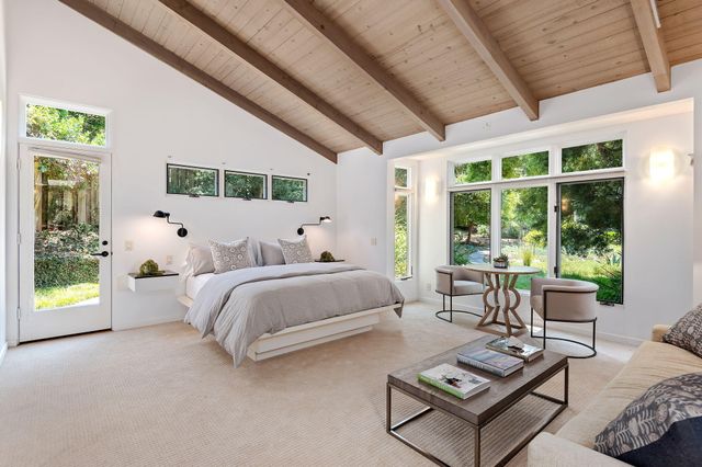 a spacious bedroom with furniture and a large window