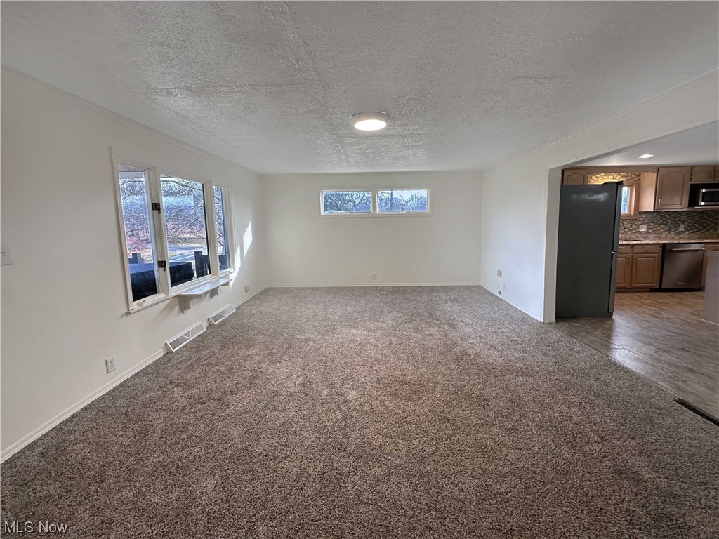 2692 Race Track Road New Cumberland, WV 26047 - Photo 7 of 25 Empty room featuring dark hardwood / wood-style floors and a textured ceiling