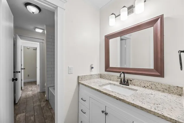 a bathroom with a granite countertop sink and a mirror