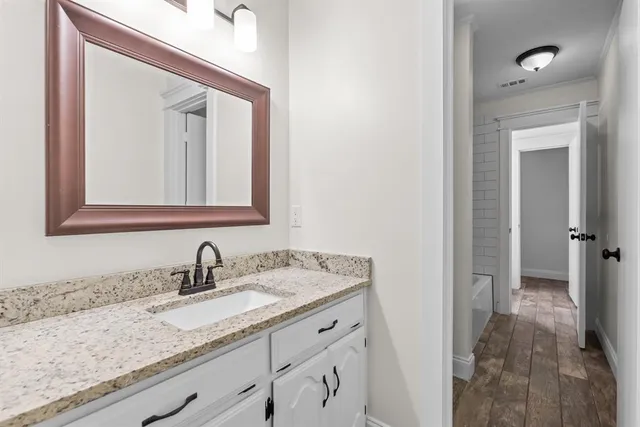 a bathroom with a granite countertop sink and a mirror