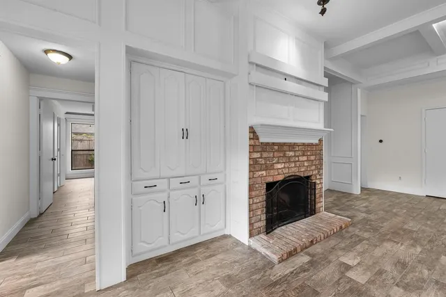 a view of an empty room with fire place and a window