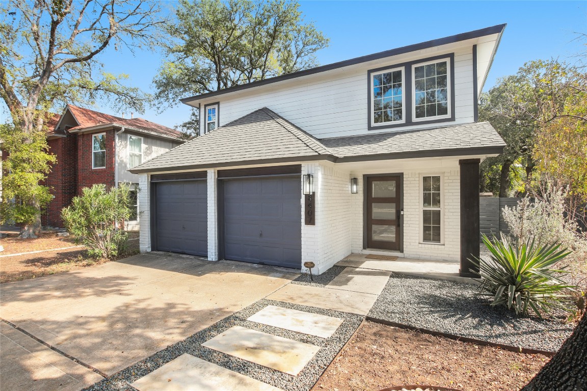 a front view of a house with a garden