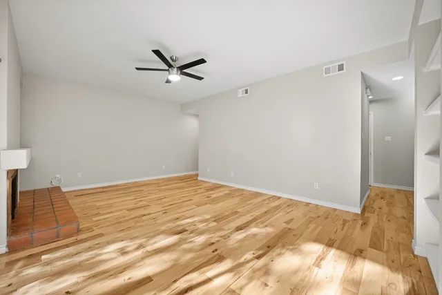 a view of a livingroom with a ceiling fan and wooden floor