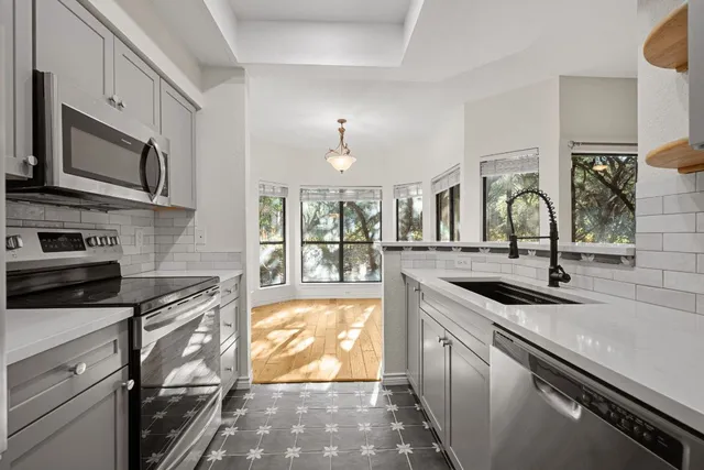 a kitchen with stainless steel appliances granite countertop a sink and stove
