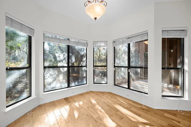 a view of an empty room with a window and a bed