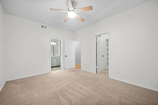 an empty room with fan and a ceiling fan