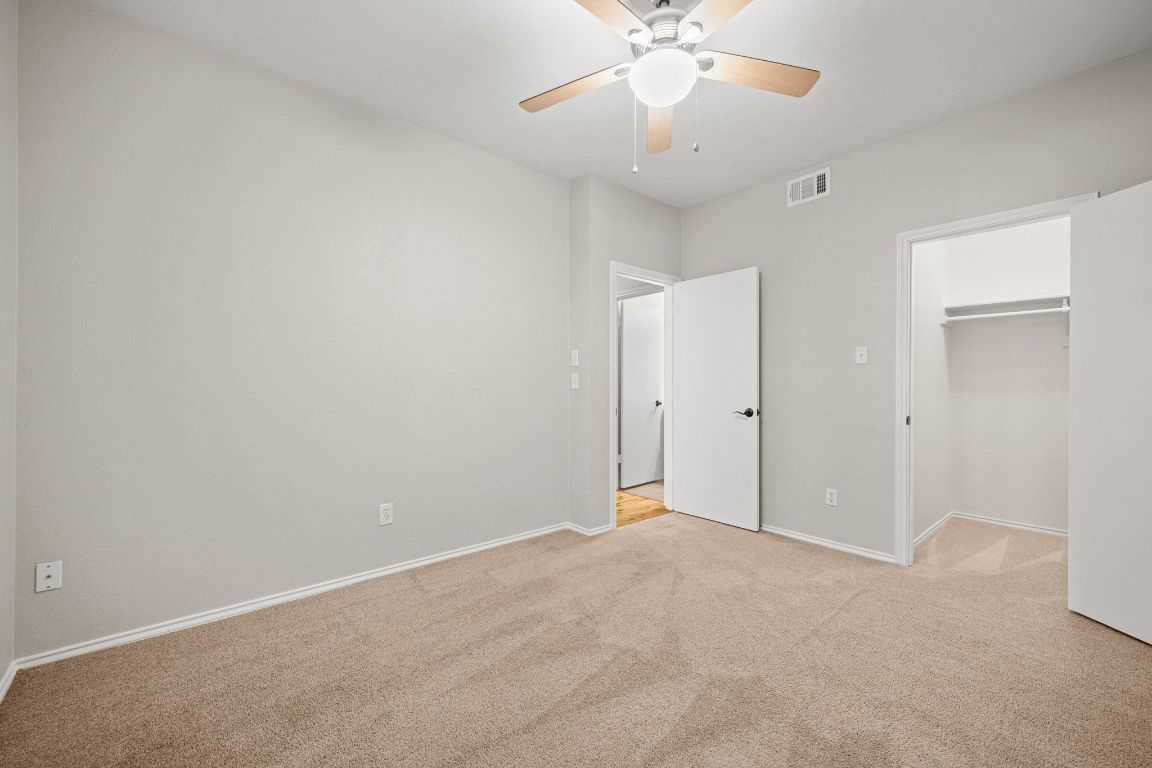 4711 Spicewood Springs Road, Unit 2107 Austin, TX 78759 - Photo 22 of 26 an empty room with a chandelier fan and a ceiling fan