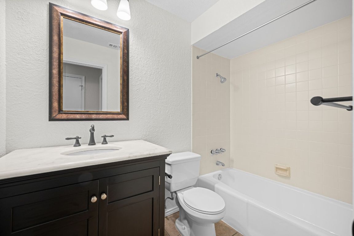 4711 Spicewood Springs Road, Unit 2107 Austin, TX 78759 - Photo 23 of 26 a bathroom with a toilet a sink a mirror a bathtub and vanity