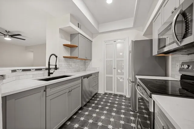 a kitchen with stainless steel appliances granite countertop a sink stove and cabinets