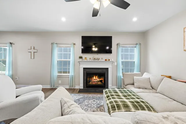 a living room with furniture a flat screen tv and a fireplace