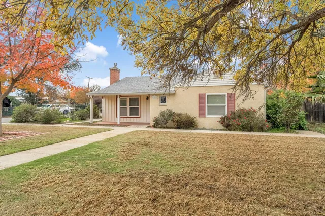a front view of house with yard and trees around