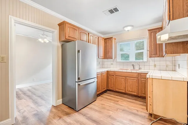 a kitchen with stainless steel appliances granite countertop a refrigerator and a sink