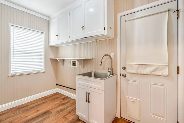 a kitchen with white cabinets and sink