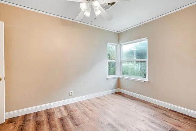 wooden floor in an empty room with a window