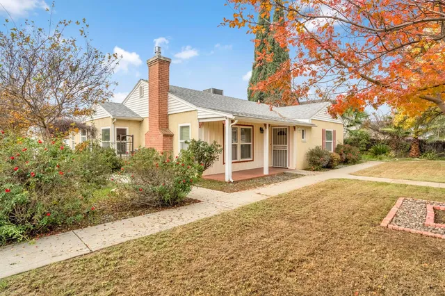 a front view of a house with a yard and potted plants