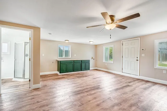 a view of an empty room and window with wooden floor