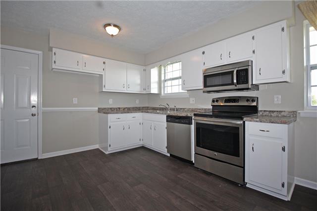 7813 Bob Carr Road Cross Plains, TN 37049 - Photo 2 of 8 a kitchen with granite countertop white cabinets and stainless steel appliances