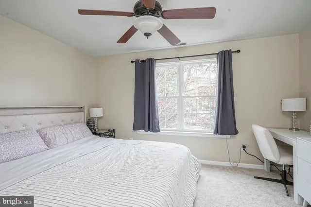 a bedroom with a bed window and a desk