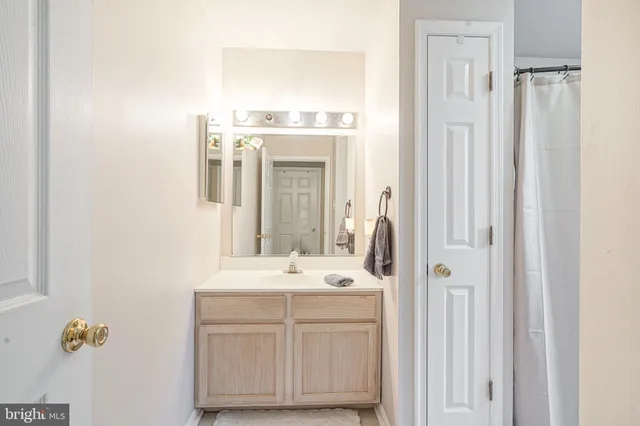 a bathroom with a sink vanity and a mirror