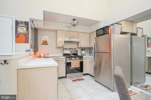 a kitchen with stainless steel appliances granite countertop a refrigerator sink stove and cabinets