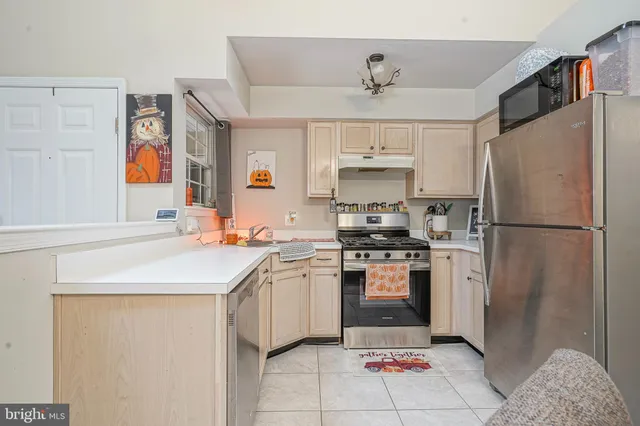 a kitchen with stainless steel appliances granite countertop a sink a stove a refrigerator and a refrigerator