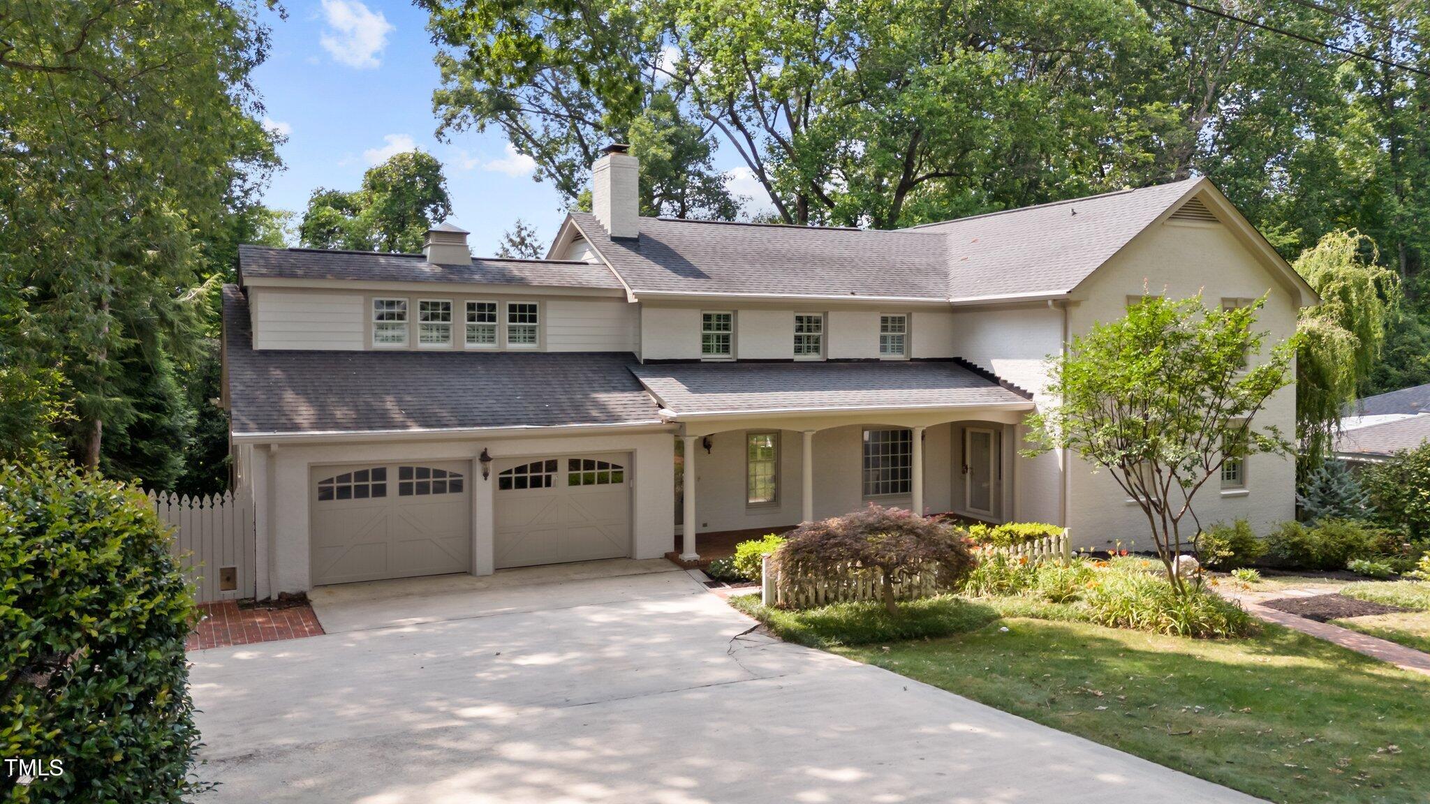 1817 Stillwater Drive Raleigh, NC 27607 - Photo 13 of 58 a view of a white house with a yard plants and large tree