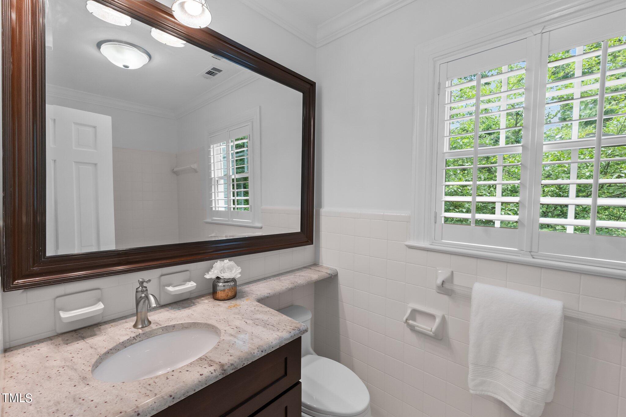 1817 Stillwater Drive Raleigh, NC 27607 - Photo 21 of 58 a bathroom with a granite countertop sink and a mirror