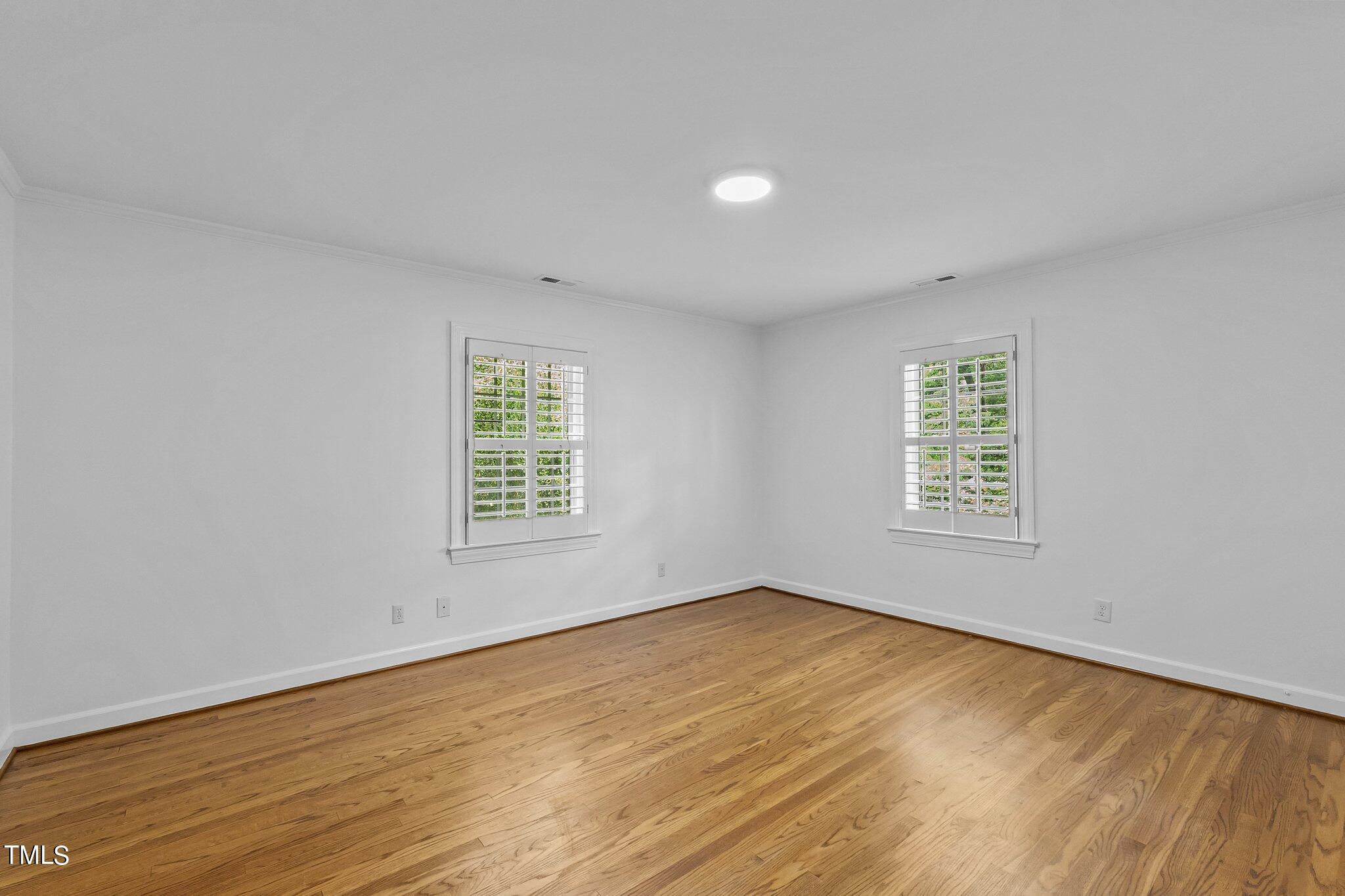 1817 Stillwater Drive Raleigh, NC 27607 - Photo 24 of 58 a view of an empty room with wooden floor and a window