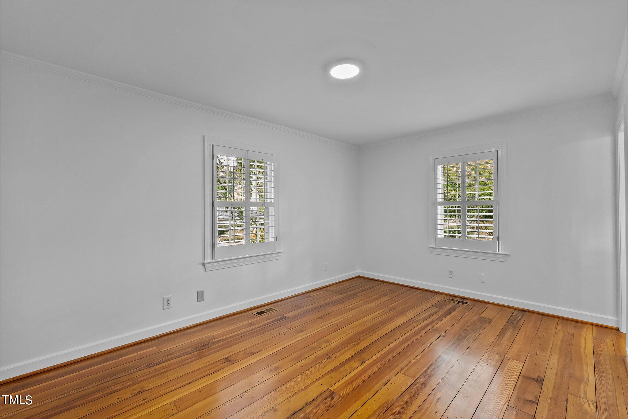 1817 Stillwater Drive Raleigh, NC 27607 - Photo 29 of 58 a view of an empty room with wooden floor and a window