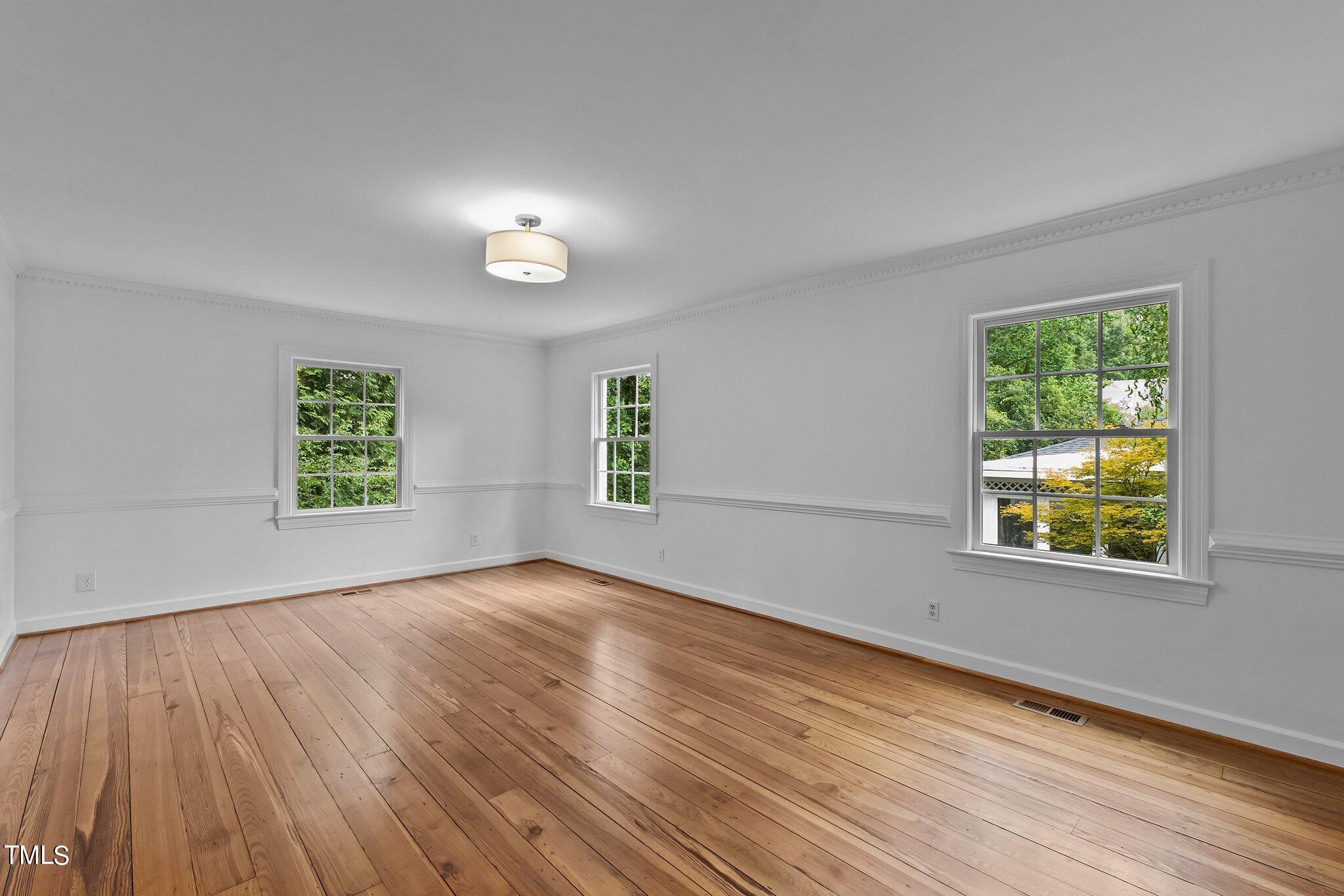 1817 Stillwater Drive Raleigh, NC 27607 - Photo 32 of 58 a view of an empty room with a window and wooden floor