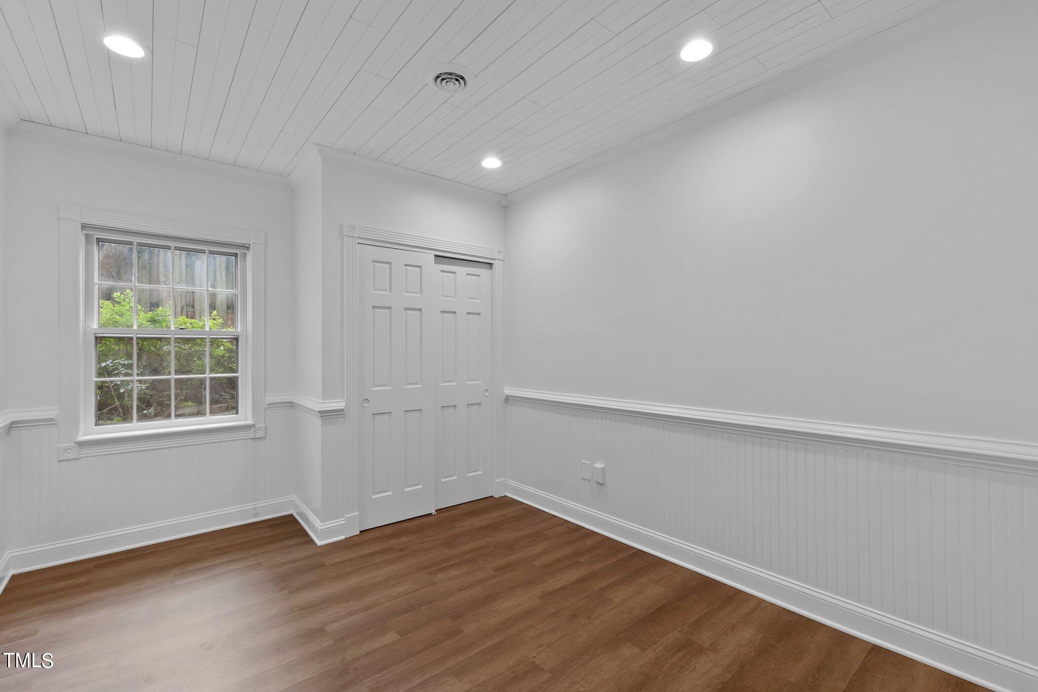 1817 Stillwater Drive Raleigh, NC 27607 - Photo 50 of 58 an empty room with wooden floor and windows