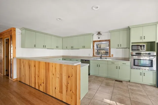 a kitchen with granite countertop a stove top oven sink and cabinets
