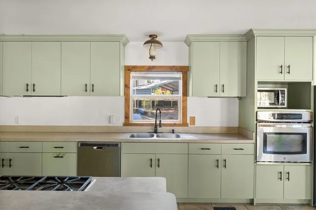 a kitchen with a sink cabinets and stainless steel appliances