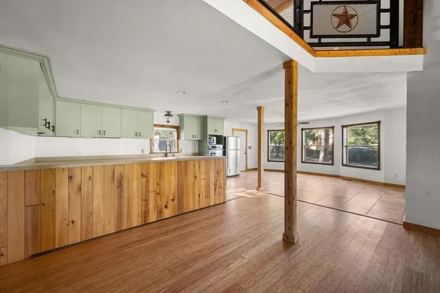 a hallway with wooden floor and chandelier