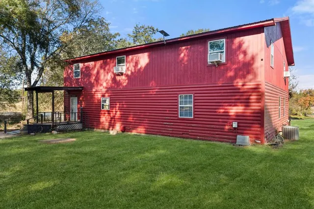 a view of a backyard with plants and large tree