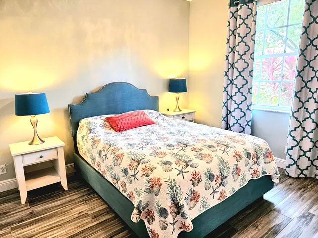a bedroom with a bed and a lamp on dresser