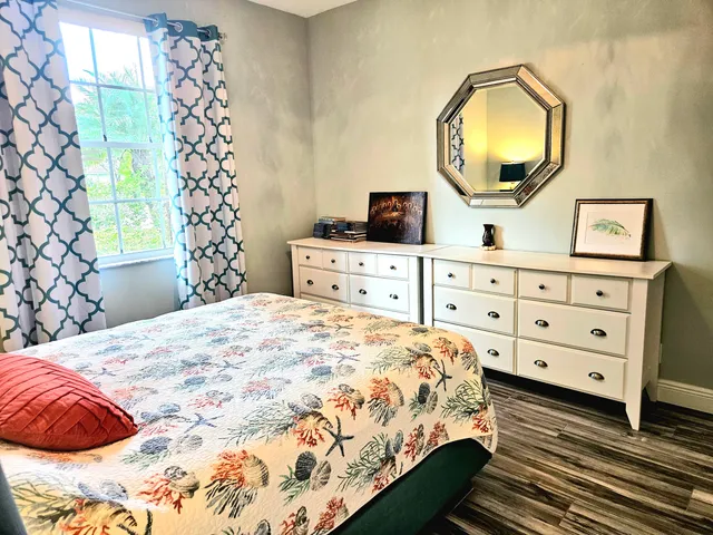 a bedroom with a bed and a mirror on the dresser