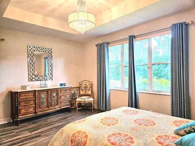 a spacious bedroom with a bed and a dresser next to a window