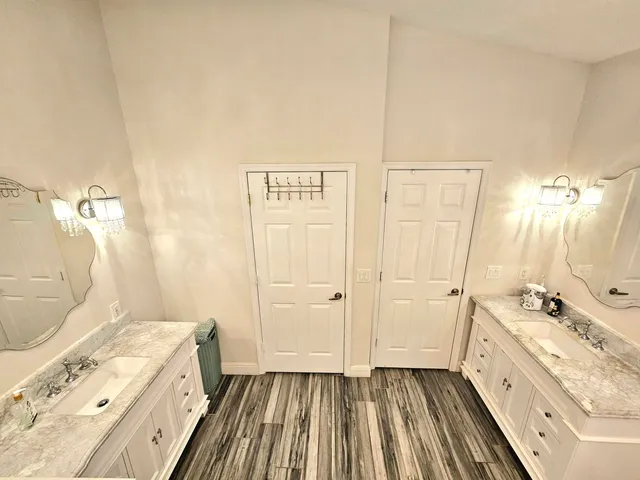 a spacious bathroom with a granite countertop sink a mirror and a shower